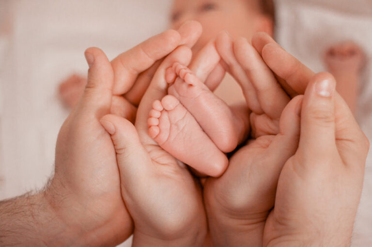 Mains parents et pieds bébé famille heureuse